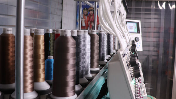Machine à broder Bartavel — bobines de fils multicolores